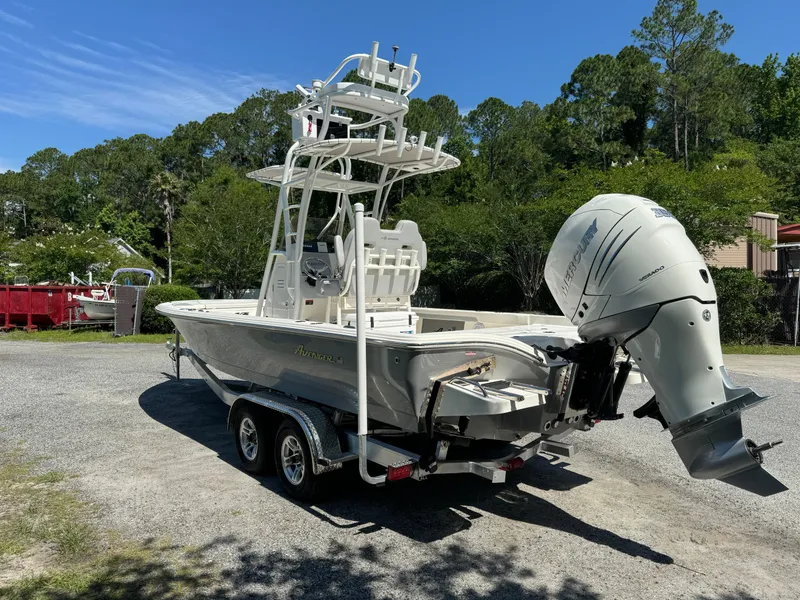 Slide: The Image of 2024 Avenger AV26 boat on trailer with outboard motor, parked outdoors. - 5