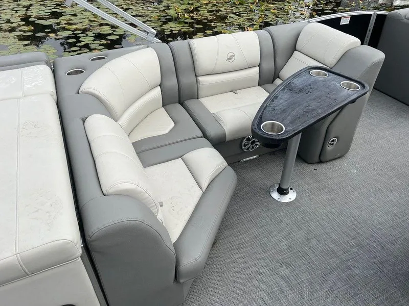 Slide: The Image of 2018 Starcraft 23 C boat interior with gray seating and table, on a calm water setting. - 5