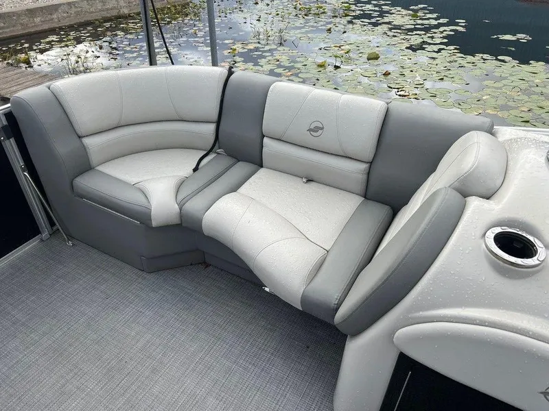 Slide: The Image of 2018 Starcraft 23 C boat interior with gray cushioned seating by water lilies. - 6