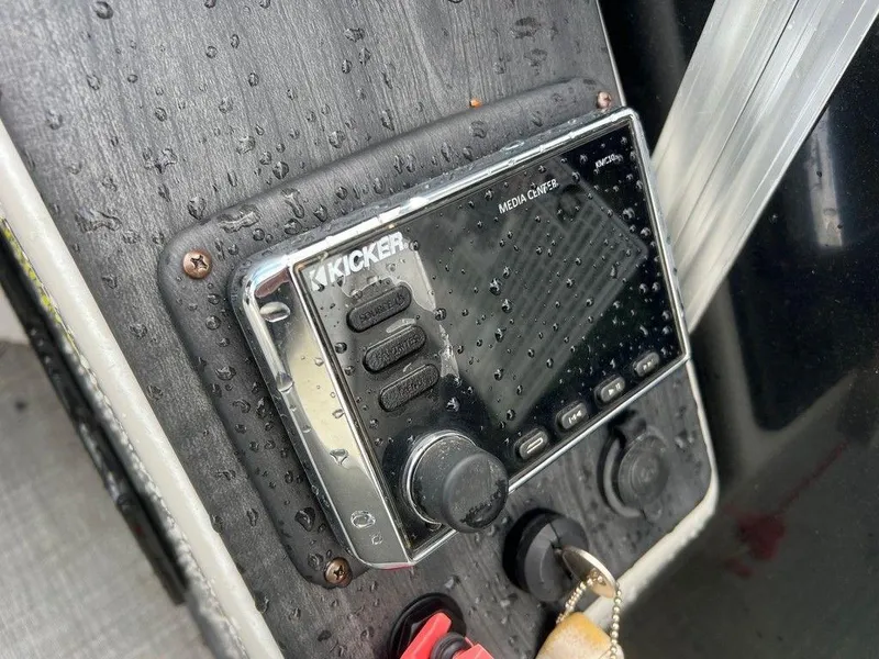 Slide: The Image of Kicker media console on 2018 Starcraft 23 C, wet with raindrops. - 9