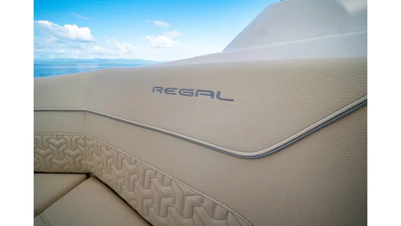 Slide: The Image of 2022 Regal LS36 boat interior with elegant beige upholstery and logo. - 12