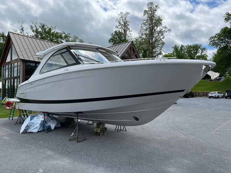 Slide: The Image of 2022 Regal LS36 boat on display outdoors, surrounded by trees and buildings. - 19