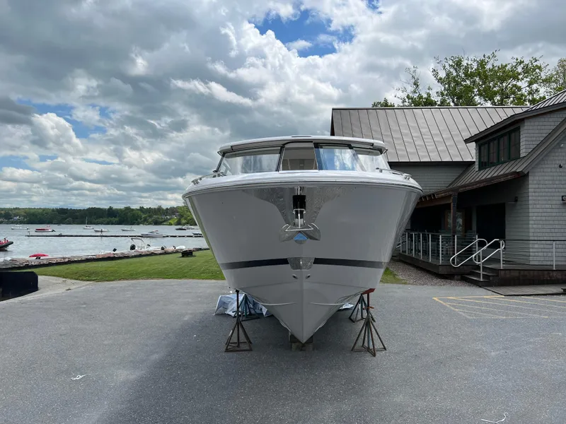 Slide: The Image of 2022 Regal LS36 boat on land near a lake and building under cloudy sky. - 25