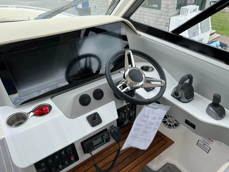 Slide: The Image of 2022 Regal LS36 boat helm with steering wheel, controls, and navigation screen. - 41