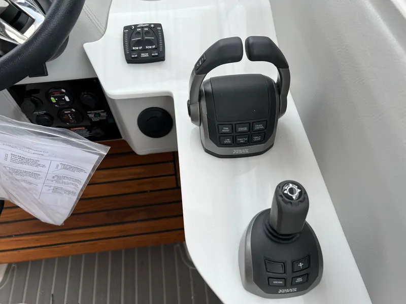 Slide: The Image of 2022 Regal LS36 boat controls with joystick and throttle on white console. - 43