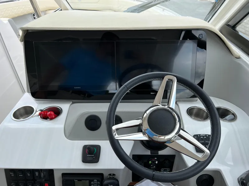 Slide: The Image of 2022 Regal LS36 boat dashboard with steering wheel and control panel. - 44