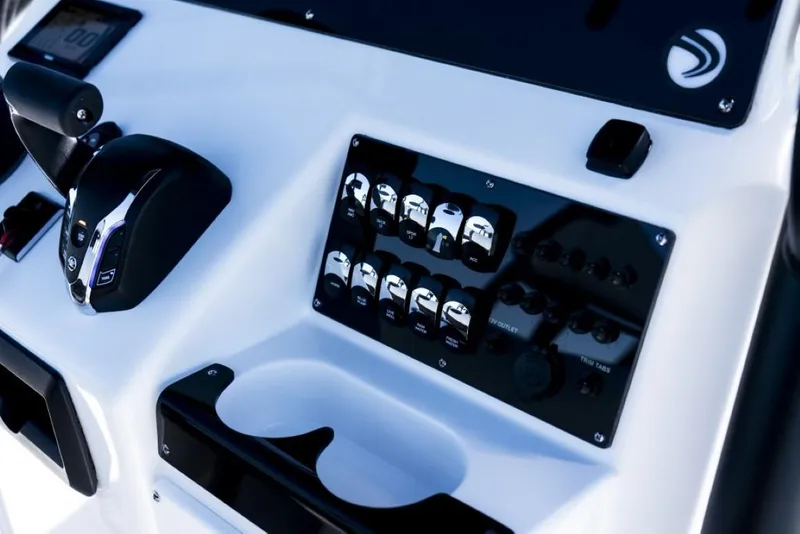 Slide: The Image of Edgewater 208CC Watchman 2025 boat dashboard with controls and cup holder. - 15
