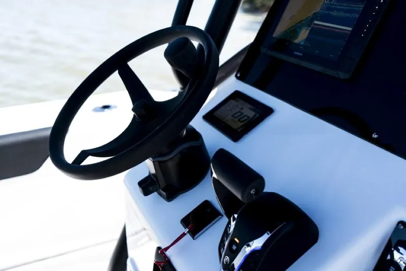 Slide: The Image of Close-up of 2025 Edgewater 208CC Watchman boat dashboard with steering wheel and controls. - 16