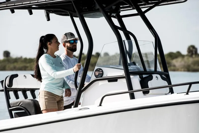 Slide: The Image of Couple navigating Edgewater 208CC Watchman boat, 2025 model, on a sunny day. - 4