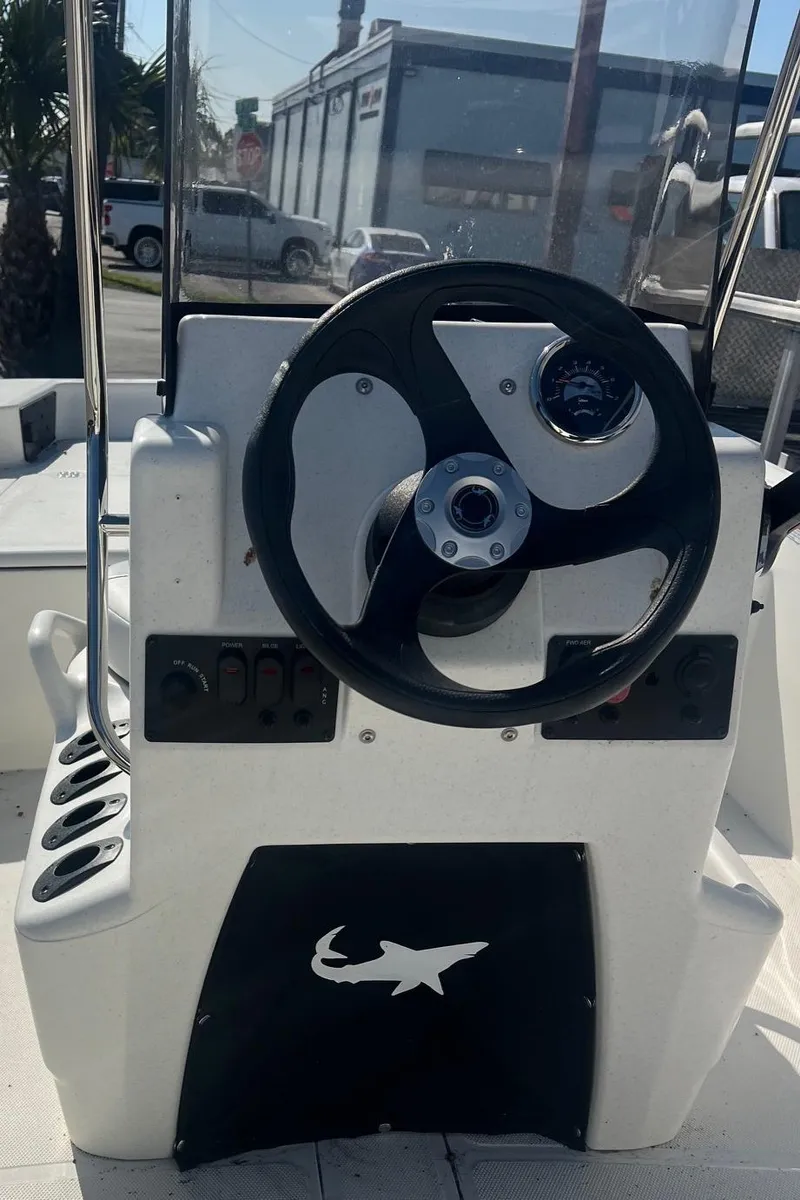 Slide: The Image of 2025 Mako Pro Skiff 15 CC steering console with black wheel and control panel. - 8