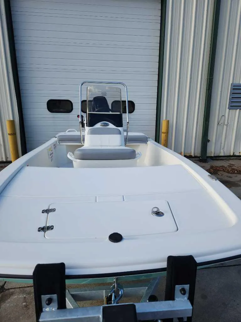 Slide: The Image of 2025 Mako Pro Skiff 13 CC boat in front of a garage door. - 2