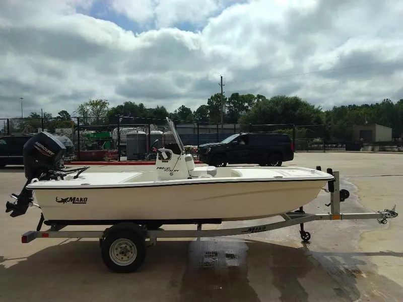 Slide: The Image of 2025 Mako Pro Skiff 13 CC boat on trailer in parking lot. - 1