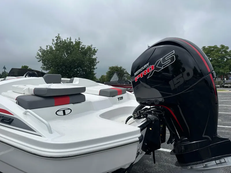 Slide: The Image of 2025 Tahoe T21 boat with Mercury Pro XS 150 engine, parked outdoors. - 2