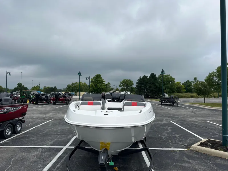 Slide: The Image of 2025 Tahoe T21 boat in parking lot, overcast sky, surrounded by trees and other boats. - 3