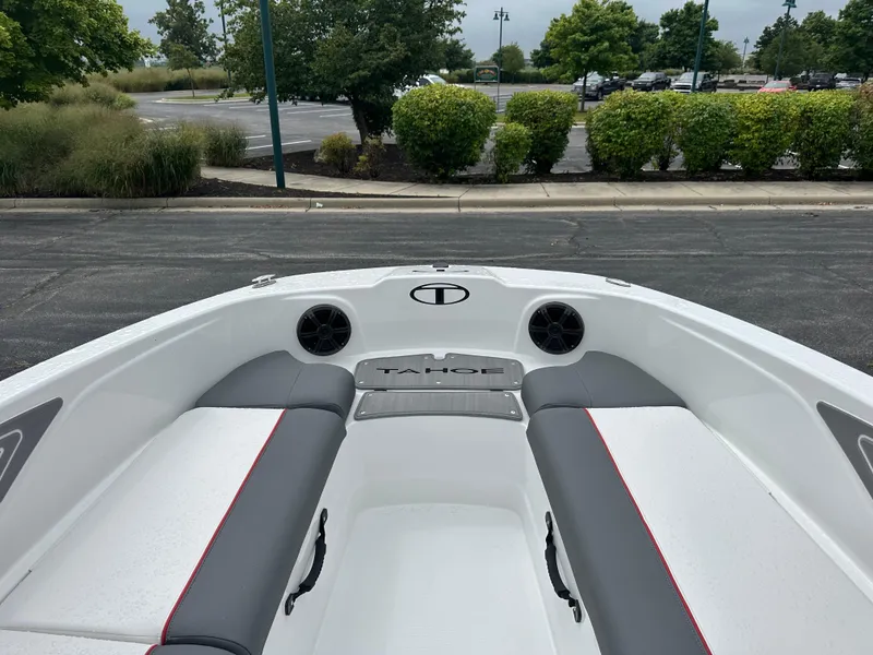 Slide: The Image of 2025 Tahoe T21 boat interior with gray and white seating, parked outdoors. - 6