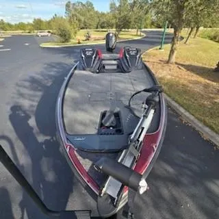 Slide: The Image of 2025 Nitro Z21 XL bass boat parked on asphalt, surrounded by trees. - 3