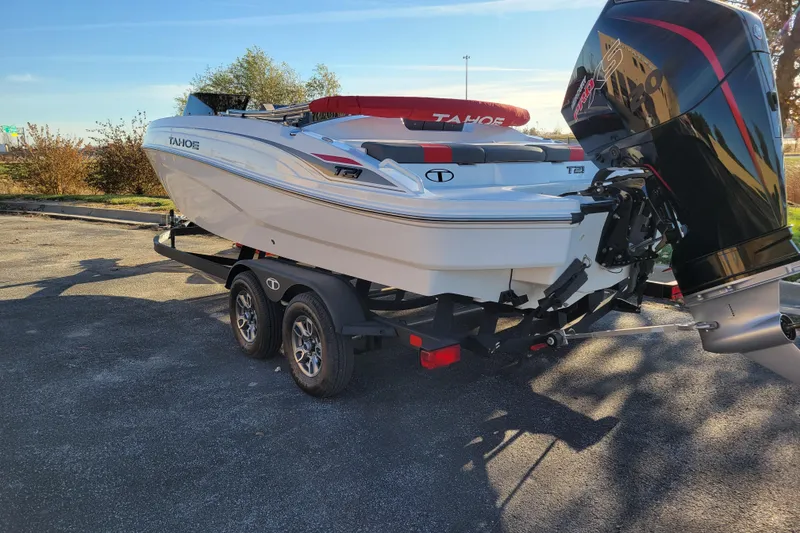 Slide: The Image of 2025 Tahoe T21 boat on trailer with powerful outboard motor, parked outdoors. - 72