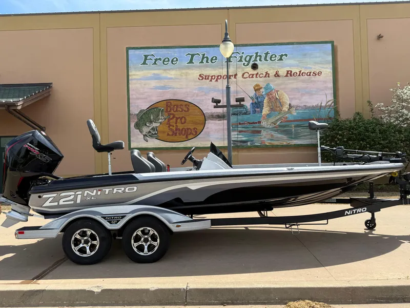 The Image of 2025 Nitro Z21 XL boat on trailer, parked near fishing-themed mural. - 0