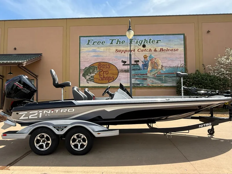 Slide: The Image of 2025 Nitro Z21 XL boat on trailer, parked outside Bass Pro Shops. - 2