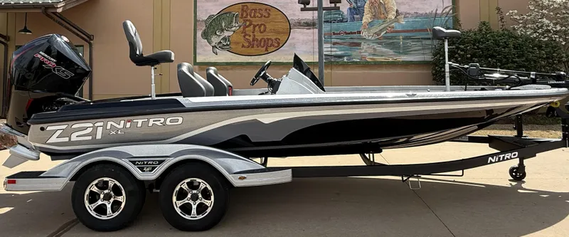 Slide: The Image of 2025 Nitro Z21 XL boat on trailer outside Bass Pro Shops. - 3