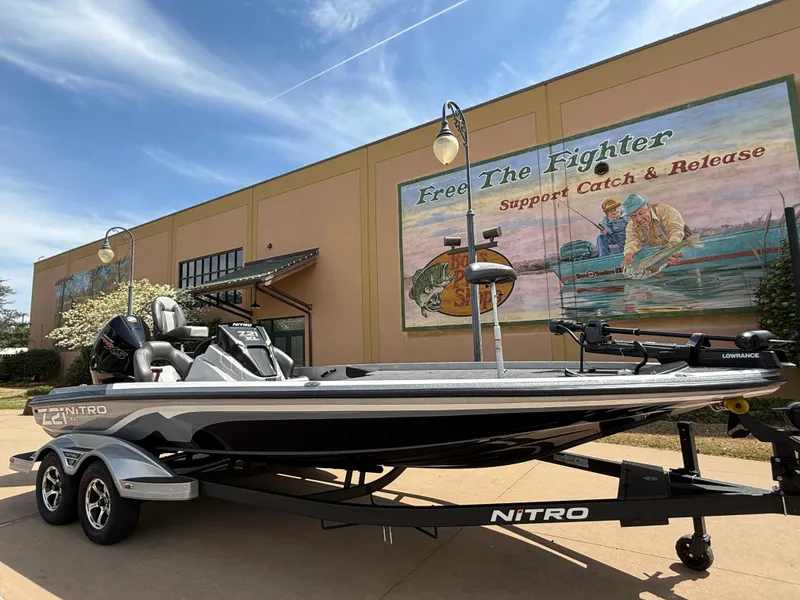 Slide: The Image of 2025 Nitro Z21 XL boat on trailer, parked near mural promoting catch and release fishing. - 4