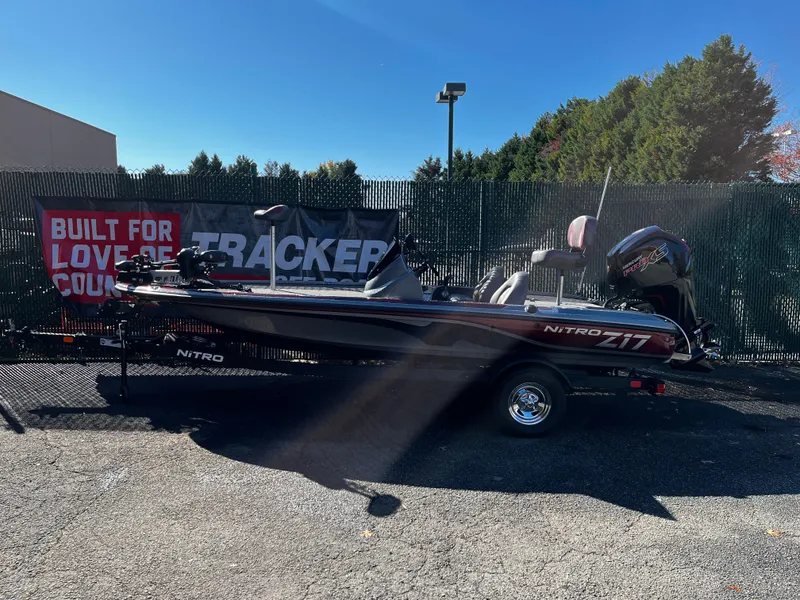 The Image of 2025 Nitro Z17 fishing boat on trailer, parked outdoors with autumn foliage. - 0