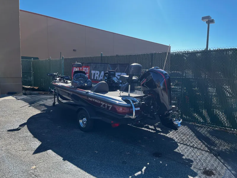 Slide: The Image of 2025 Nitro Z17 boat with powerful outboard motor in a parking lot. - 2