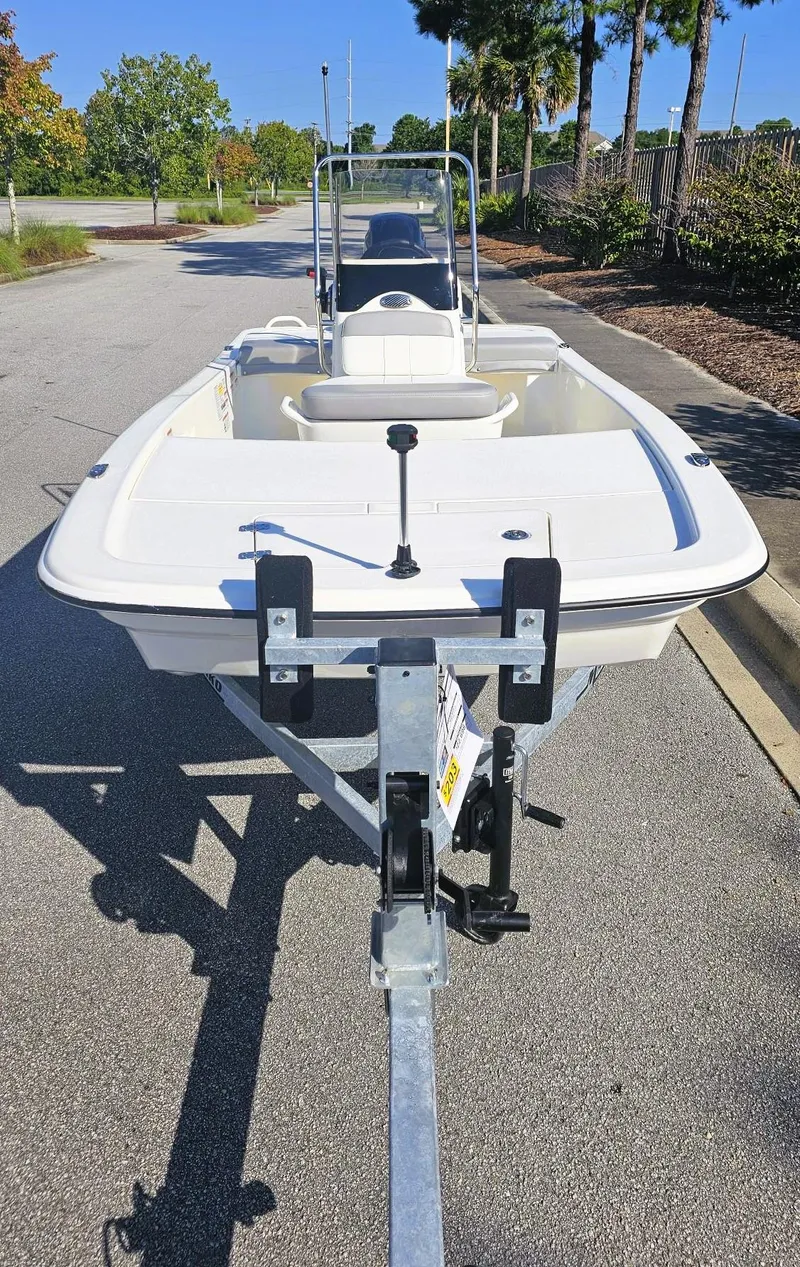 Slide: The Image of 2025 Mako Pro Skiff 13 CC boat on trailer, parked on a sunny street. - 6