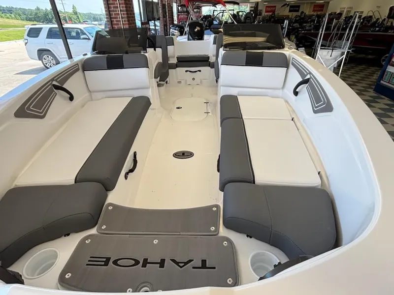 Slide: The Image of 2025 Tahoe T21 boat interior with gray and white seating, displayed in a showroom. - 2