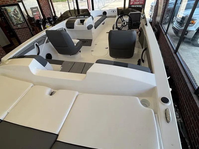 Slide: The Image of 2025 Tahoe T21 boat interior with seating and steering wheel in showroom. - 3