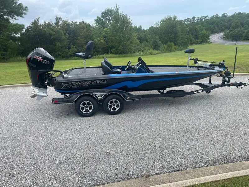 The Image of 2025 Nitro Z21 XL bass boat on trailer, parked on a road. - 0