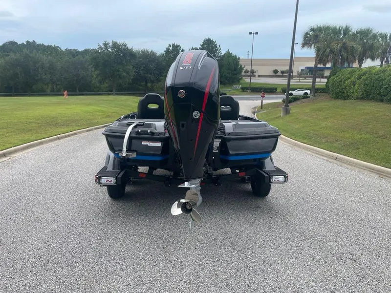 Slide: The Image of 2025 Nitro Z21 XL boat on trailer, rear view, parked on a paved road. - 2