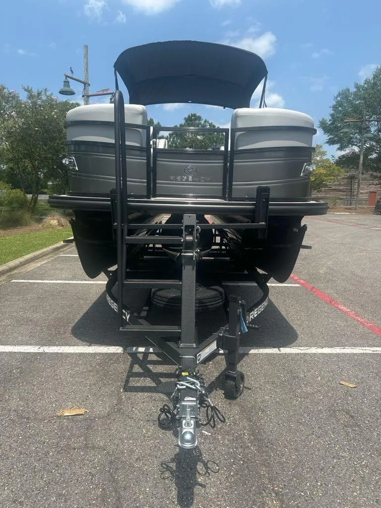 Slide: The Image of 2025 Regency 230 DL3 pontoon boat on trailer, parked in sunny lot. - 3