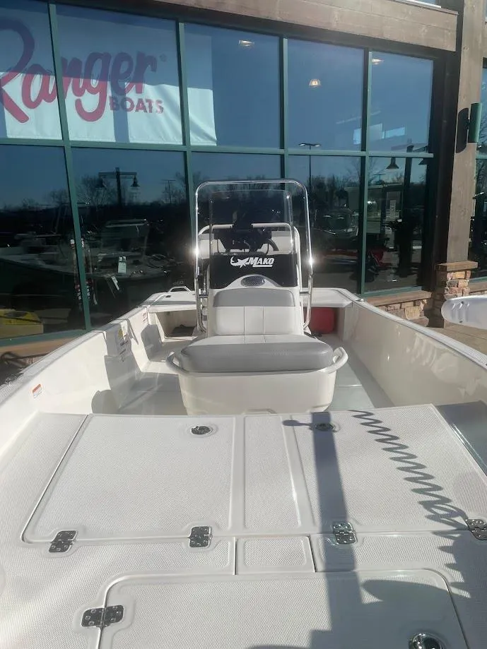 Slide: The Image of 2025 Mako Pro Skiff 15 CC boat displayed outside a showroom. - 2