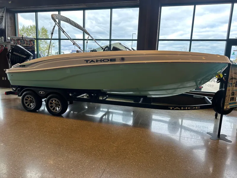 Slide: The Image of 2025 Tahoe T21 boat on display in showroom with trailer. - 0