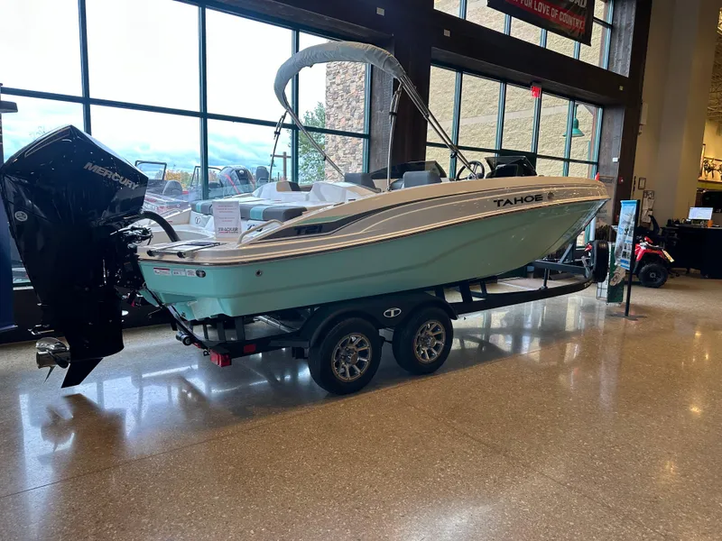 Slide: The Image of 2025 Tahoe T21 boat on display indoors with trailer. - 1
