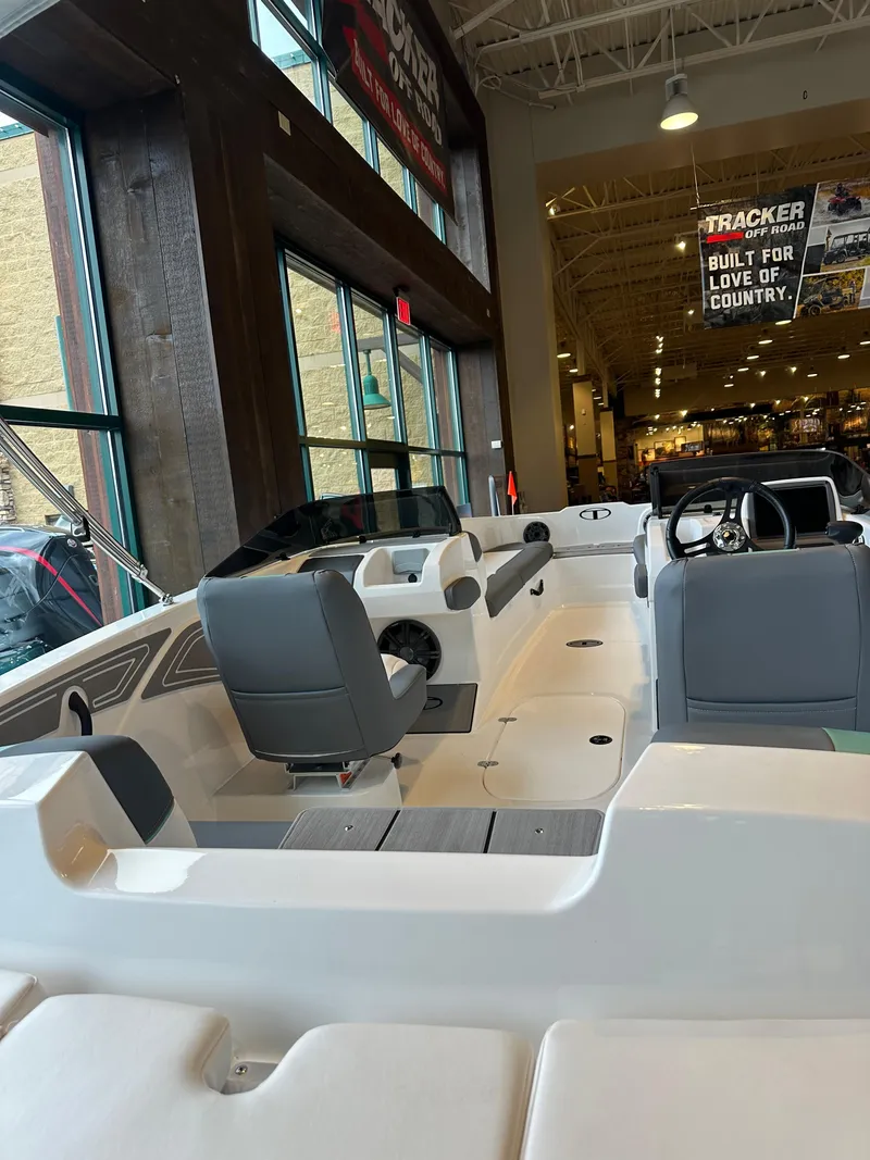 Slide: The Image of 2025 Tahoe T21 boat interior in showroom, featuring sleek seating and modern design. - 2