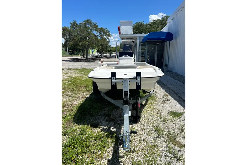 Slide: The Image of 2025 Mako Pro Skiff 13 CC boat on trailer, parked outdoors near building. - 47