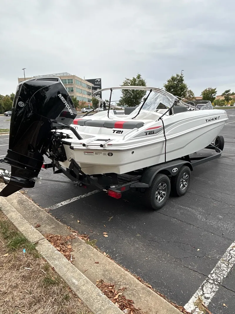 Slide: The Image of 2025 Tahoe T21 boat on trailer in parking lot, featuring sleek design and powerful outboard motor. - 4