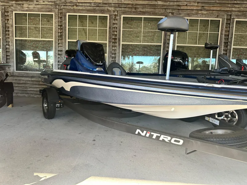 Slide: The Image of 2025 Nitro Z17 boat parked outside a rustic building. - 0