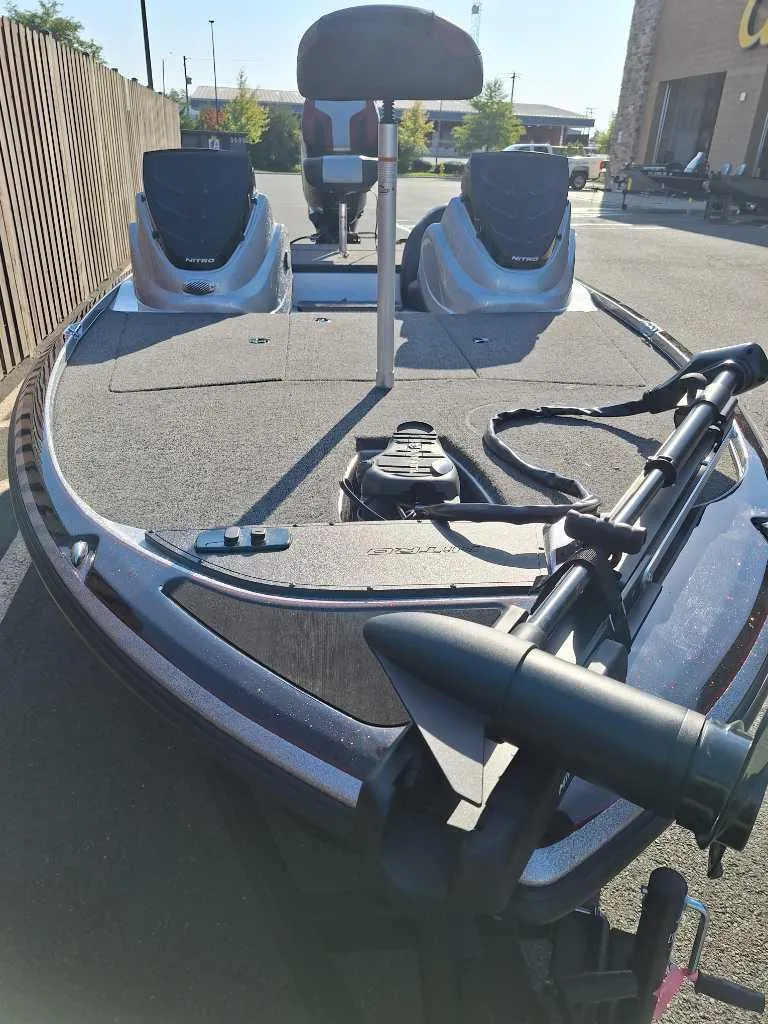 Slide: The Image of 2025 Nitro Z17 fishing boat with dual seats and trolling motor, parked outdoors. - 4