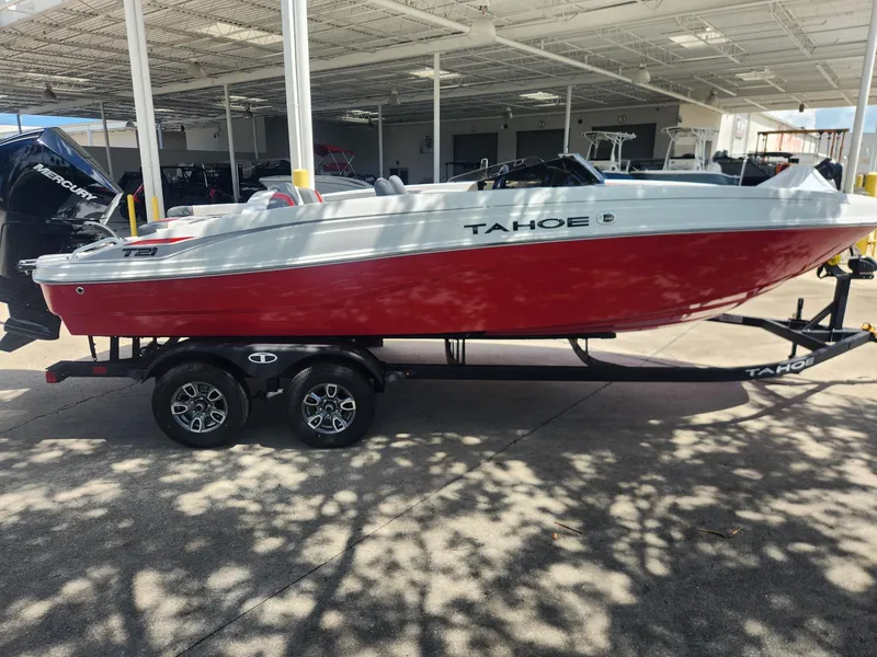 Slide: The Image of 2025 Tahoe T21 boat with red hull on trailer in showroom. - 1
