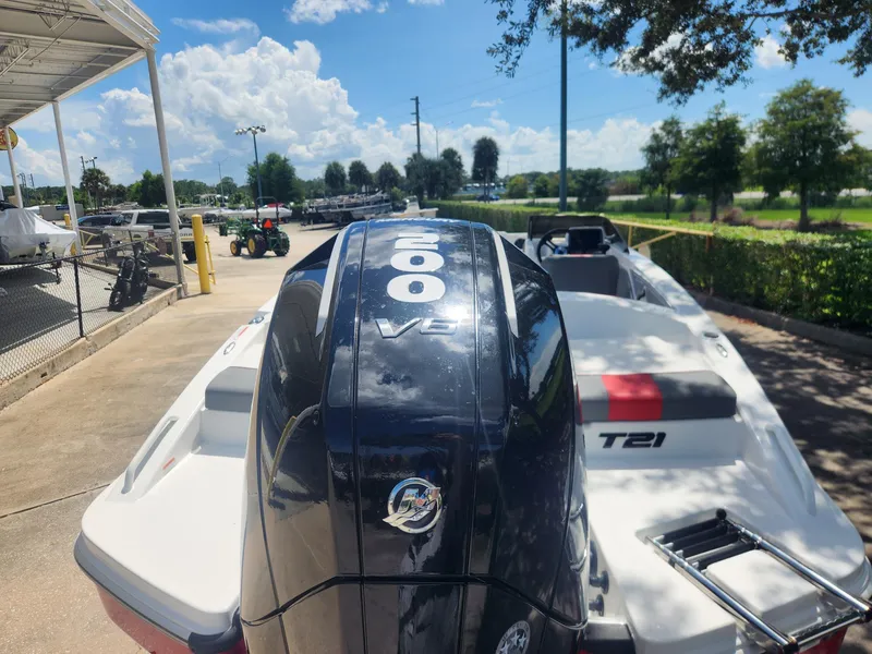 Slide: The Image of 2025 Tahoe T21 boat with 200 HP engine, parked outdoors under a sunny sky. - 4