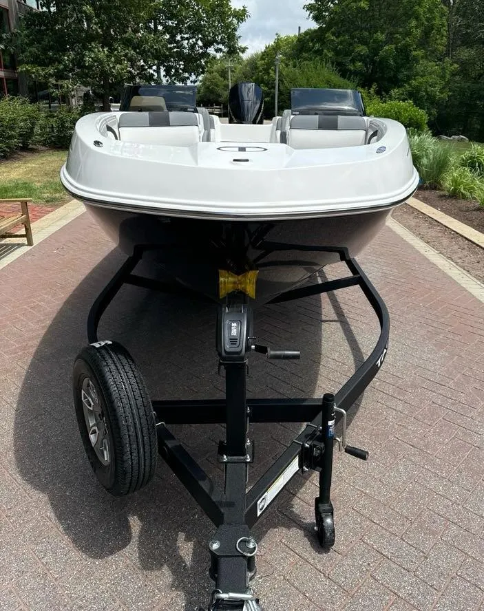 Slide: The Image of 2025 Tahoe T21 boat with outboard motor, parked on a brick driveway. - 3