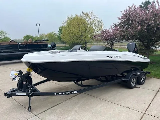Slide: The Image of 2025 Tahoe T21 boat on trailer, parked outdoors with trees in the background. - 4