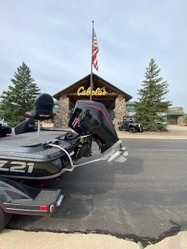 Slide: The Image of 2025 Nitro Z21 XL boat parked outside Cabela's store with American flag. - 4