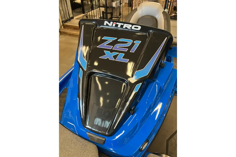 Slide: The Image of 2025 Nitro Z21 XL Pro boat, sleek design with blue accents, showcased indoors. - 13