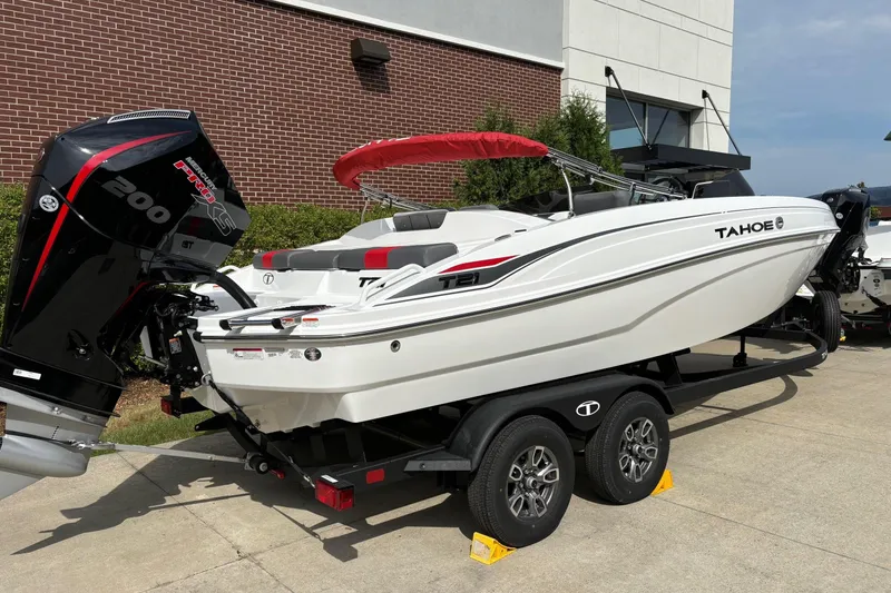 The Image of 2025 Tahoe T21 boat on trailer with powerful outboard motor, parked outdoors. - 0