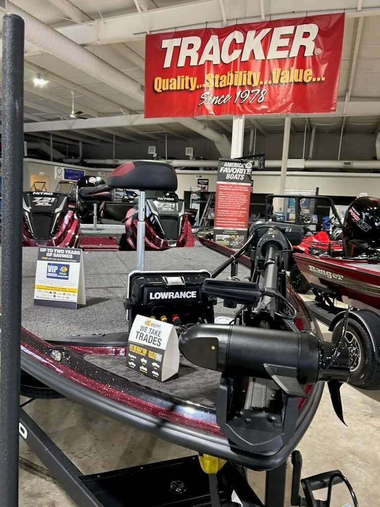 Slide: The Image of 2025 Nitro Z21 XL boat with Lowrance equipment in showroom, Tracker banner above. - 3