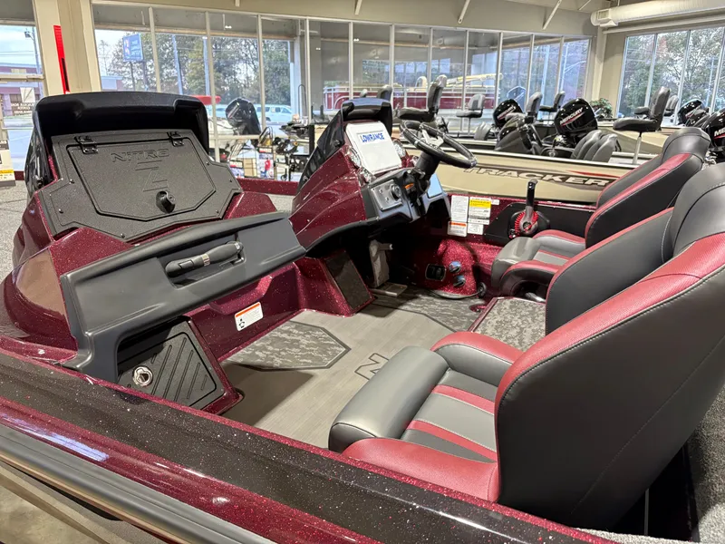 Slide: The Image of 2025 Nitro Z21 XL boat interior with red and black seating in showroom. - 5